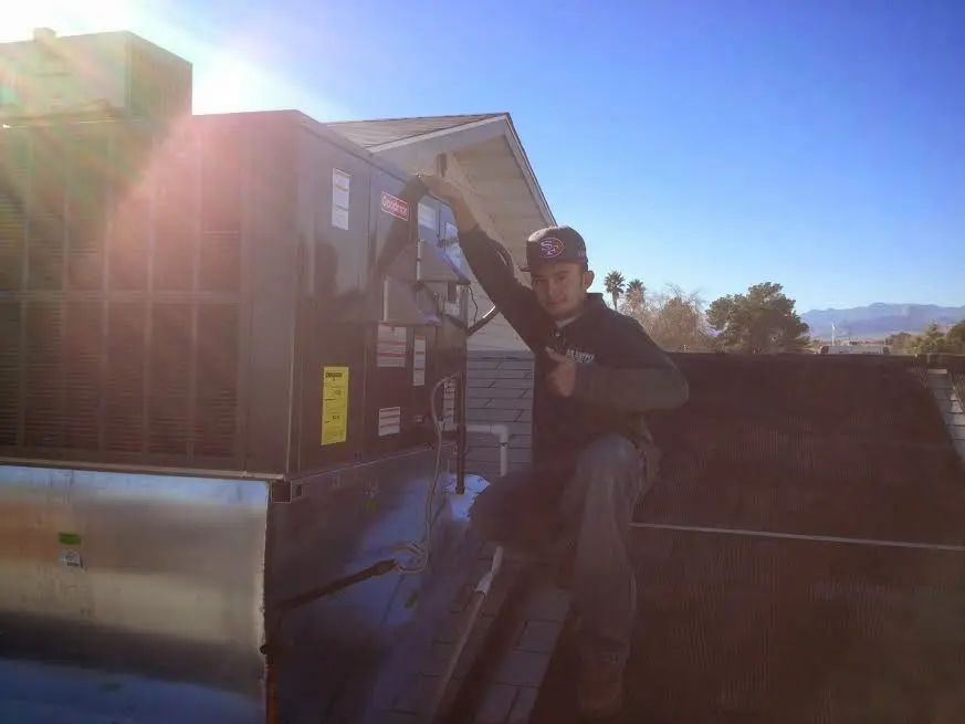 HVAC technician performing Air Duct Cleaning on a rooftop unit in Brookside